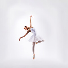 Fototapeta premium Ballet dancer isolated on white. Beautiful ballerina performing in studio.