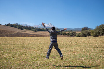 Man in mid-jump with volcano in the background