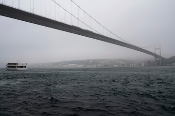 View of the Martyrs' Bridge on July 15 (Bosphorus Bridge) and the Asian part of the city from the Bosphorus on a foggy day, Istanbul, Turkey.