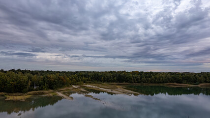 The photograph presents a vast landscape where a still lake reflects the complex patterns of a...