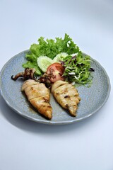 Grilled squids or 'Cumi Bakar' is a sweet and tangy seafood dish that is often sold as street food in Indonesia. It is marinated in sweet soy sauce and a mixture of spices before being grilled. 