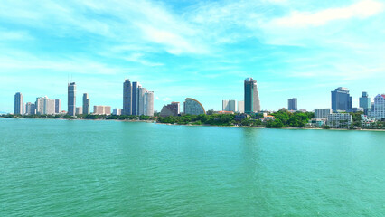 Naklejka premium The beach is a vibrant marine activity hub for vacationers. Relax with sunbathing, enjoy water sports, or try thrilling parasailing. Lined with a variety of hotels, and restaurants. Pattaya, Thailand.