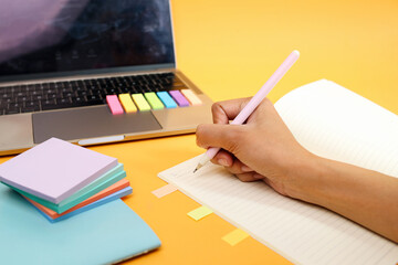 Hand Writing on Notes In Front Of Laptop With Colorful Memo Pads and Page Marker for Highlighting Journal 
