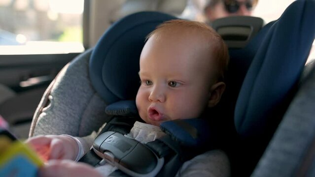 child securely seated in a car seat. Capture the joy and excitement of travel, the child's wonder at the passing scenery, and the importance of safe travel for families. Ideal for family travel vlogs,