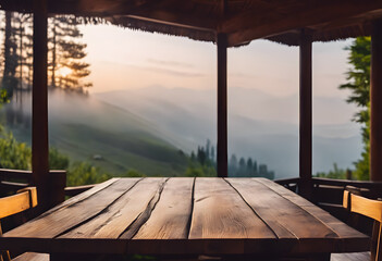 Wooden table and chairs on a terrace overlooking a misty mountain landscape at sunrise, creating a serene and inviting atmosphere.