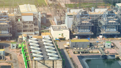 Fototapeta premium A mesmerizing aerial vista of a sprawling power plant, its colossal turbines humming with energy, surrounded by a labyrinth of steel and concrete. 