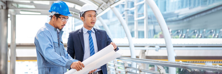 Banner Two engineer man look at blueprint architecture building contractor designer. Engineer holding project planing partner teamwork. Two Man meeting together construction site with copy space
