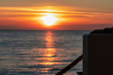 Selective focus of wooden bar item with sunset view in Sveti Stefan, Adriatic Mediterranean Sea,...