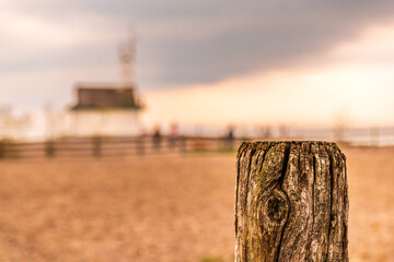 wooden fence post in the field background of beach sand and sky room for text