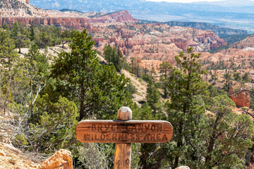 Wooden sign saying Bryce Canyon Wilderness Area at the start of the Fairyland Trail in the Amphitheatre, Bryce Canyon National Park, Utah, USA. Selective focus on informational sign