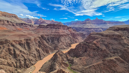 Panoramic aerial view of Colorado River weaving through valleys and rugged terrain seen from...