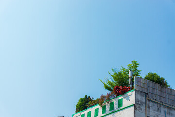 The Weathered Rooftop with Peeling Paint Contrasts Against the Clear Blue Sky. Horizontal Image with Copy Space