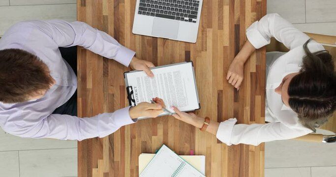 Two people signing important contract in office top view