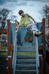 boy climbing on a childrens slide at the playground in the park