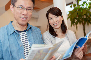 雑誌を見る中年夫婦