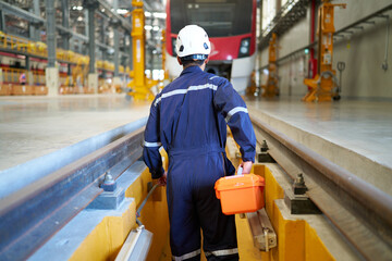 back technician or engineer holding tool box for fixing the train at construction site