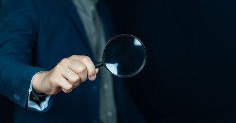 Business people holding magnifying glass on concept of finding something with blank space for copy...