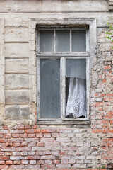 Fototapeta na wymiar verlassenes Haus, kaputtes Fenster mit Gardine