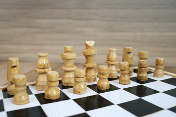Chess board with white chess pieces on rustic wooden surface