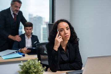 Exhausted Latino young businesswoman overworking in office workplace. 