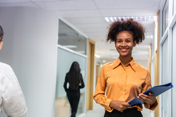 African american young businesswoman smiling and walking in corridor. 