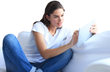 Beautiful young woman using tablet sitting on sofa at home on a transparent background