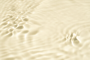 Natural background of water in summer. Beige surface. Clear water with ripples and splashes. water waves in sunlight The water surface has waves.