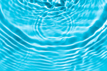 Background summer natural blue texture, clear water with ripples and splashes. Water waves in sunlight with leaf shadow, and background concept of cosmetics, moisturizer, and toner.