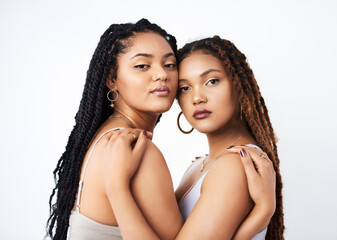 Sisters, portrait and makeup in studio, embrace and luxury cosmetics on white background. Women,...