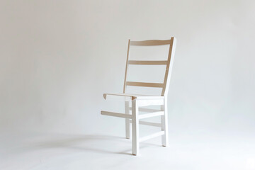 A minimalist ladderback chair with a pure white surface.