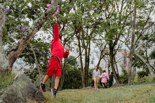 International Children Day. Latina mother having fun with her children outdoors, jumping and running. Family day. Concept of love and togetherness. Single mother of two young children.