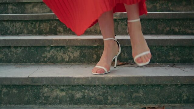 High-heels legs stepping stairs at city closeup. Unrecognizable woman walking