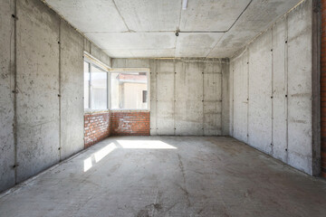 Obraz premium interior of the apartment without decoration in gray colors. rough finish