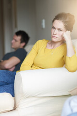 Stress, portrait and sad couple on sofa in home with anger, argument or fight in living room. Mental health, frustrated woman and man on couch with toxic relationship, divorce or marriage in crisis.