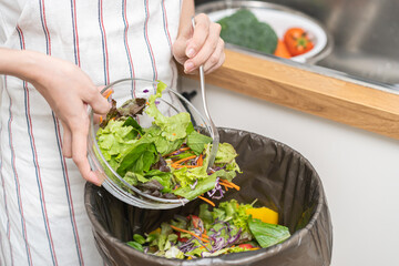 Compost from leftover food asian young housekeeper woman, female hand holding salad bowl use fork...