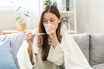 Sick, influenza asian young woman tired have a fever and sore cough hand holding thermometer for...