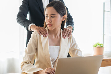 Disgusted asian young employee, pressure business woman uncomfortable, looking hand of boss or colleague  male when touching her shoulder, embrace. Sexual harassment inappropriate at office work. - obrazy, fototapety, plakaty