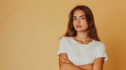 Obraz premium A woman with long brown hair is standing in front of a yellow wall