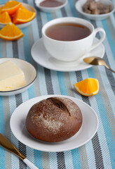 Rye bun and breakfast butter with tea and orange