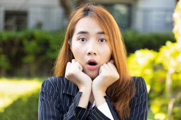 Exciting and surprised Asian office worker woman, in smart casual corporate suit