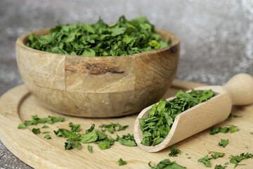 Dry parsley spice with wooden spoon in wooden bowl. Homegrown herbs and spices for cooking. Fresh...