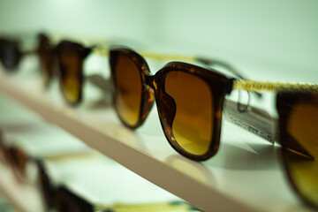 Storefront shelves of various modern sunglasses in retail store. Display rack full of sunglasses. Stand with sunglasses.
