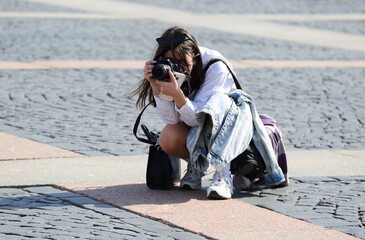 Photographer girl on the street at work, Palace Square, St. Petersburg, Russia, April 29, 2024