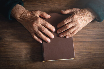 Caucasian elderly woman hands with bible.