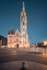 Fototapeta na wymiar Evening cityscape about Budapest with the illuminated Matthias church. Amazing attraction in Buda castle district next to Fishermans bastion. Hungarian name is Matyas templom.