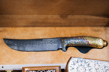oriental Uzbek chust knife made of Damascus steel in a wooden gift box in a souvenir shop in...