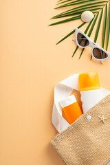 Vertical top view of SPF skincare bottles in beach bag, shades, seashells on orange backdrop....