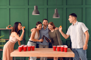 Group of young friends playing beer pong at party