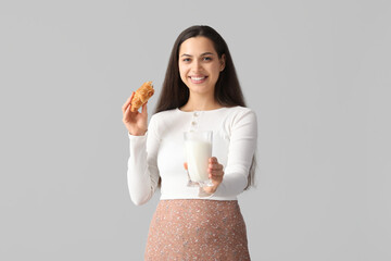 Young woman with glass of tasty milk and croissant on grey background - obrazy, fototapety, plakaty