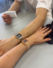 female and male hand with paired watches